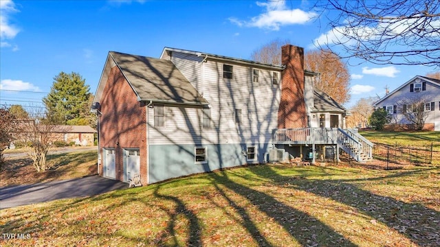 back of house featuring a yard and a garage