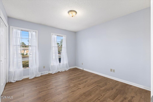 spare room with a textured ceiling and hardwood / wood-style flooring