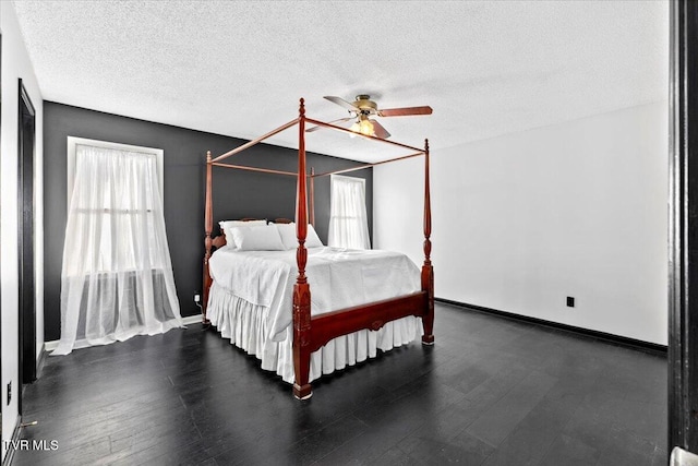 bedroom featuring ceiling fan, dark hardwood / wood-style flooring, and a textured ceiling