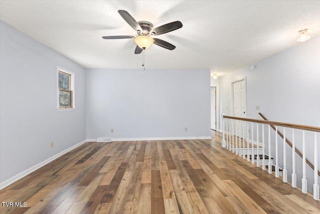 spare room with hardwood / wood-style floors, a textured ceiling, and ceiling fan