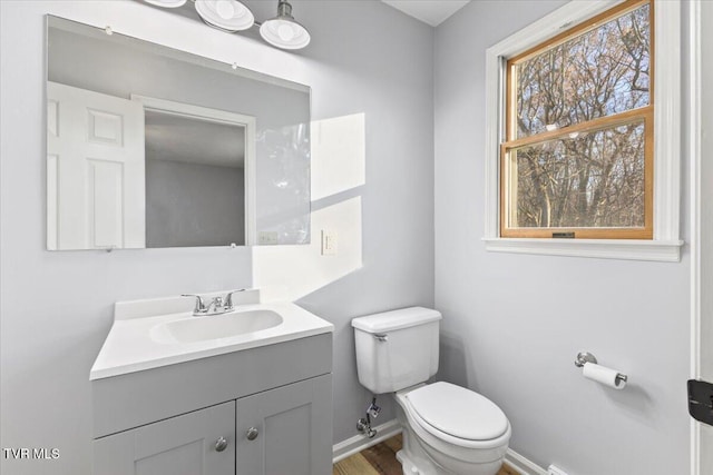 bathroom with hardwood / wood-style floors, vanity, and toilet