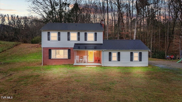 311 Dry Fork Rd, Del Rio, TN 37727 - traditional home featuring a metal roof, a chimney, a front lawn, a porch, and brick siding