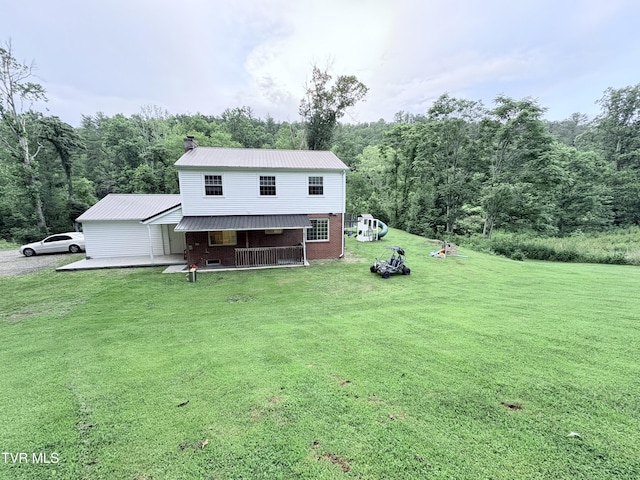 311 Dry Fork Rd, Del Rio, TN 37727 - back of property featuring a lawn, a metal roof, a wooded view, and brick siding