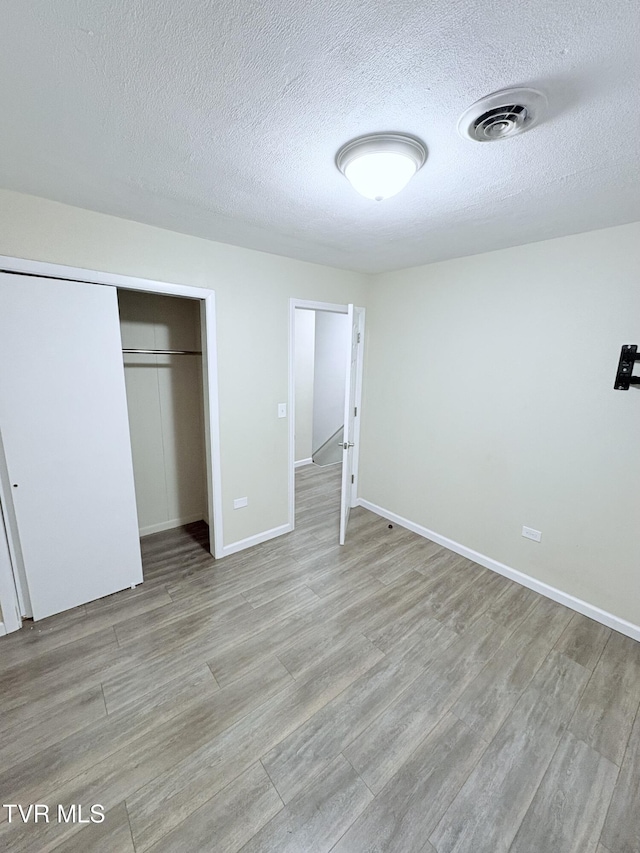 311 Dry Fork Rd, Del Rio, TN 37727 - unfurnished bedroom featuring light wood-style flooring, a textured ceiling, and a closet