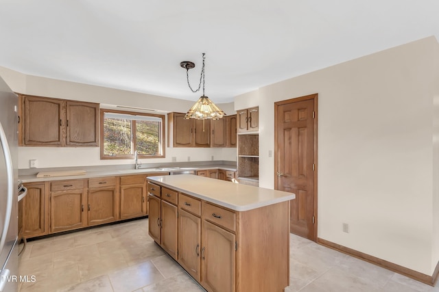 kitchen with a center island, an inviting chandelier, sink, hanging light fixtures, and stainless steel refrigerator