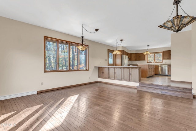 unfurnished living room with a chandelier, light hardwood / wood-style floors, and a baseboard radiator