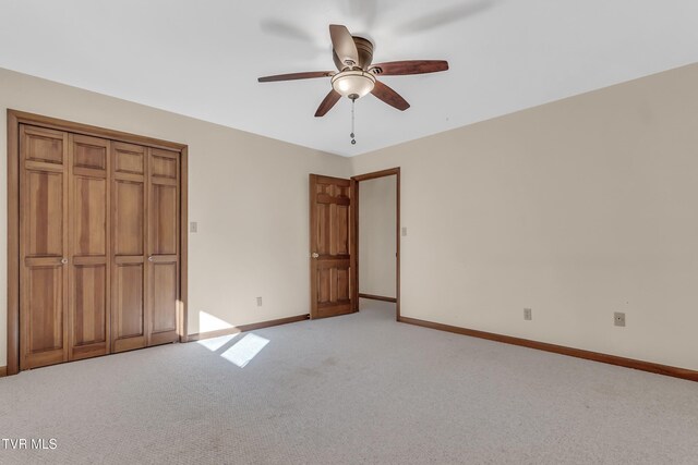 unfurnished bedroom with a closet, light colored carpet, and ceiling fan