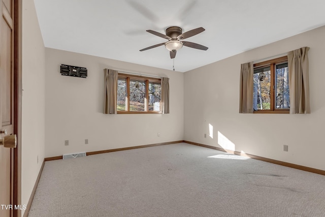 carpeted spare room featuring ceiling fan