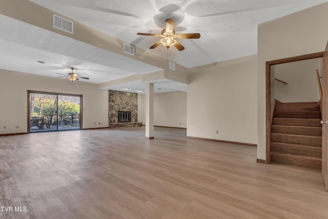 unfurnished living room with ceiling fan, light wood-type flooring, and a fireplace