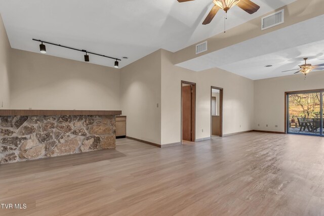 empty room with rail lighting, light hardwood / wood-style floors, and ceiling fan