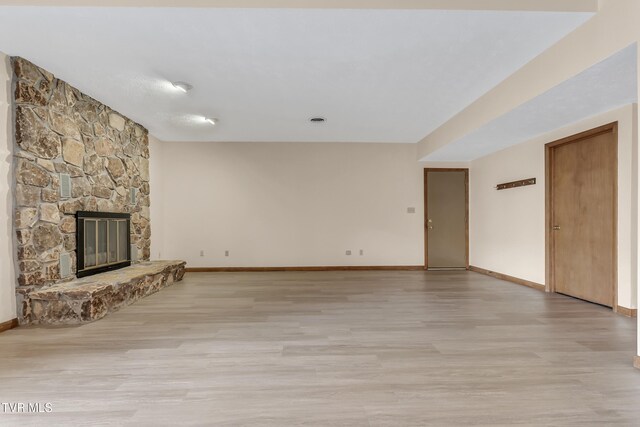 unfurnished living room with a fireplace and light hardwood / wood-style flooring