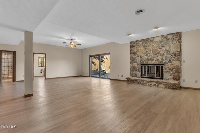 unfurnished living room featuring a fireplace, light wood-type flooring, and ceiling fan