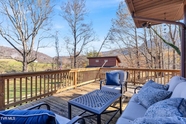 deck with a mountain view, an outdoor living space, and an outdoor structure