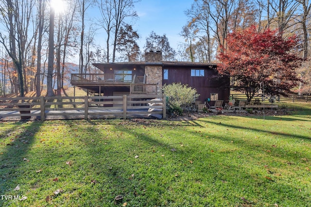 rear view of house with a yard and a wooden deck