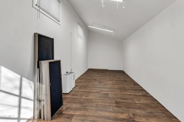 empty room with dark hardwood / wood-style floors and vaulted ceiling