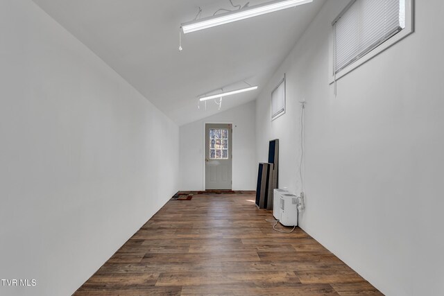 unfurnished room with dark wood-type flooring and lofted ceiling