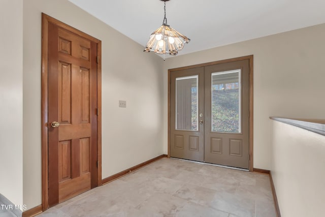 foyer entrance featuring french doors and a notable chandelier