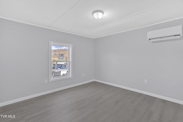 spare room featuring hardwood / wood-style floors and a wall mounted AC