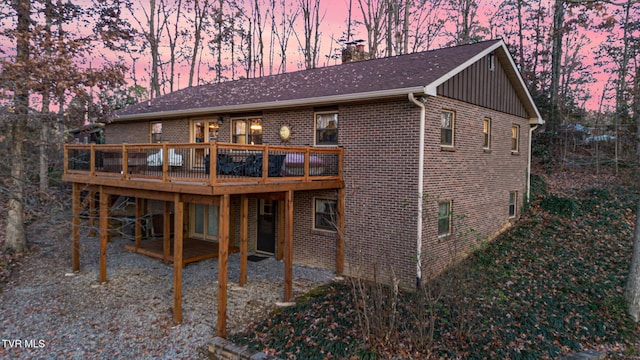 back house at dusk featuring a deck