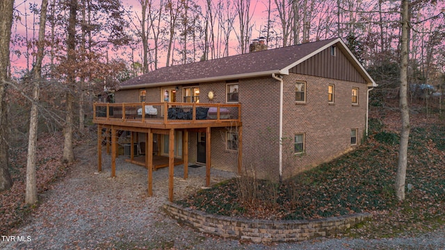 back house at dusk with a wooden deck