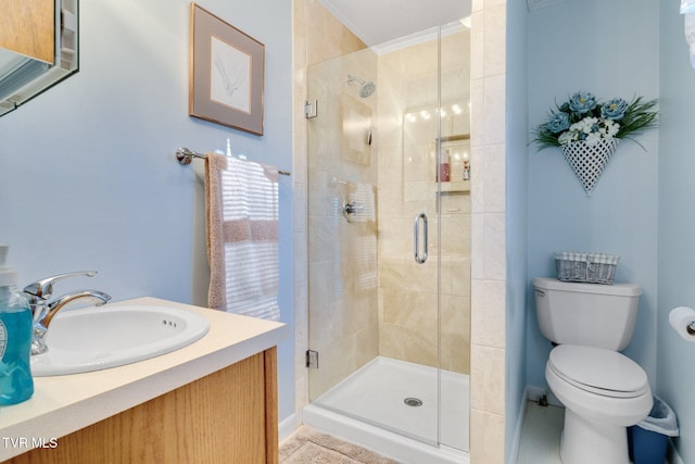 bathroom featuring a shower with door, vanity, ornamental molding, and toilet