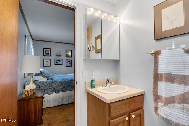 bathroom featuring hardwood / wood-style flooring, vanity, and ornamental molding