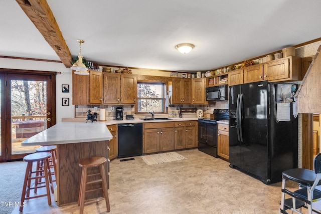 kitchen with backsplash, black appliances, sink, kitchen peninsula, and a breakfast bar area