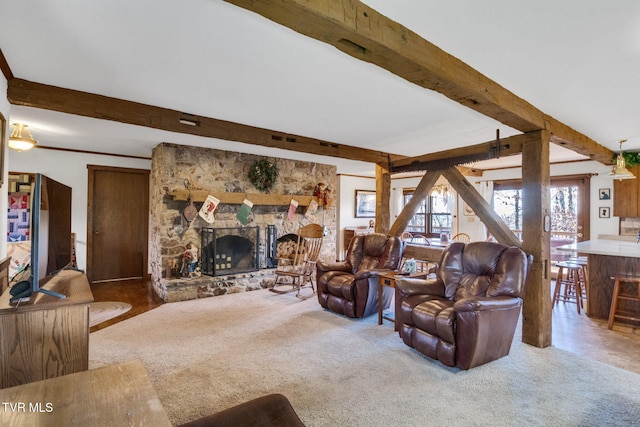 carpeted living room with beam ceiling and a stone fireplace