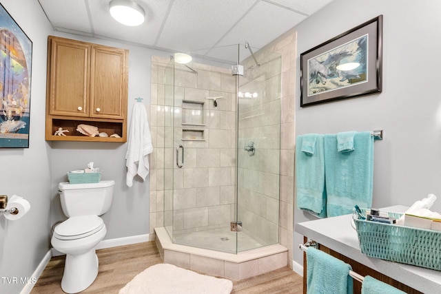 bathroom featuring a shower with shower door, toilet, and wood-type flooring