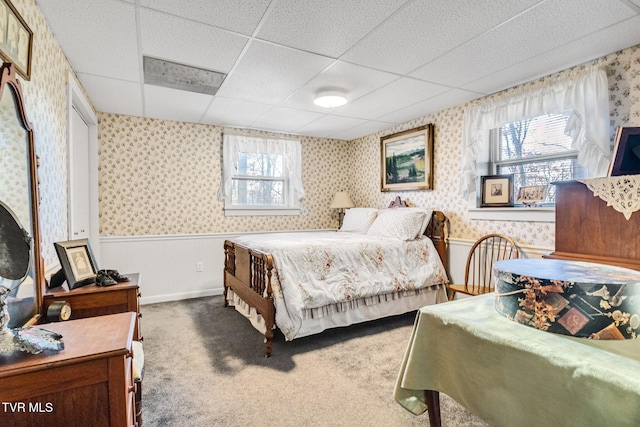 carpeted bedroom featuring a drop ceiling