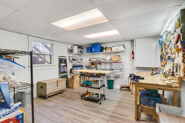 interior space featuring a drop ceiling and light hardwood / wood-style floors