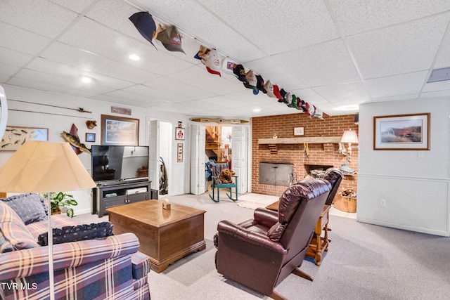 carpeted living room with a paneled ceiling and a brick fireplace