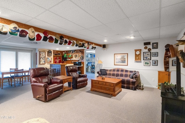 living room featuring carpet floors and a drop ceiling