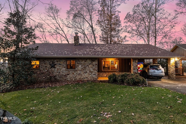 ranch-style house featuring a yard and a carport