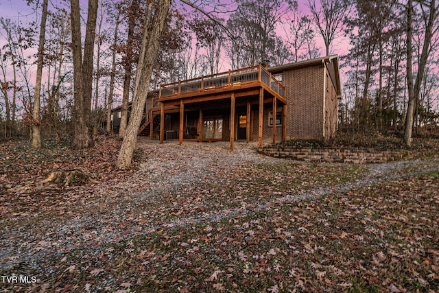 back house at dusk with a deck