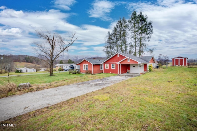 view of front of property featuring a front yard and a storage shed