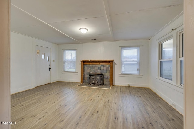 unfurnished living room featuring a wealth of natural light and light hardwood / wood-style flooring