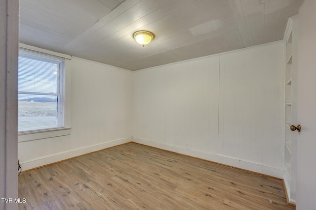 spare room featuring light hardwood / wood-style floors and ornamental molding