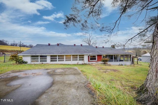 view of front of home featuring a front yard, a patio, and a sunroom