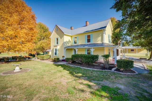 farmhouse-style home with covered porch and a front yard