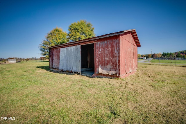 view of outdoor structure featuring a rural view and a lawn