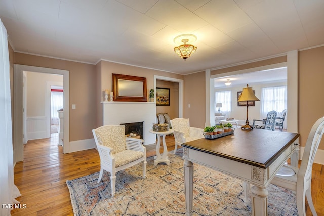 interior space featuring a brick fireplace, crown molding, and light hardwood / wood-style flooring