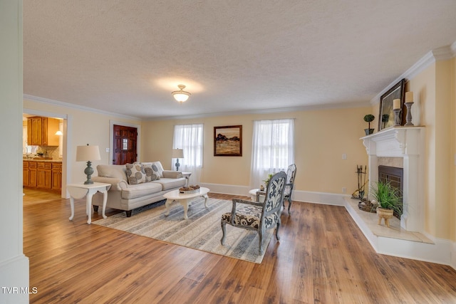 living room with hardwood / wood-style floors, ornamental molding, and a textured ceiling