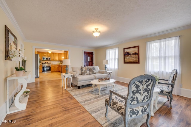 living room with crown molding, light wood-type flooring, and a textured ceiling