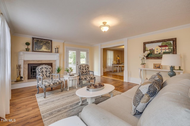 living room featuring a fireplace, wood-type flooring, french doors, and crown molding