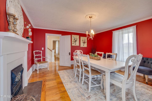 dining room with hardwood / wood-style floors, a notable chandelier, and ornamental molding