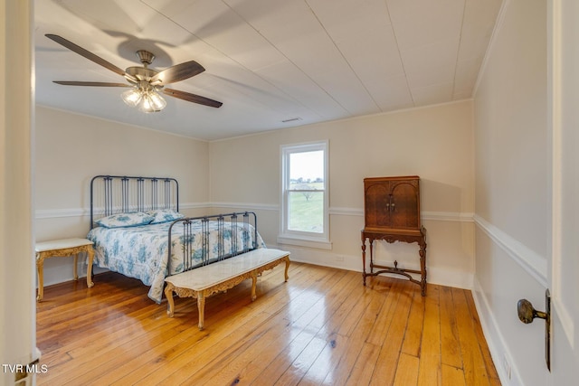 bedroom featuring ceiling fan, light hardwood / wood-style floors, and ornamental molding