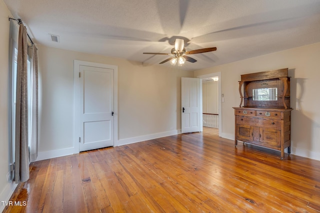 spare room with a textured ceiling, hardwood / wood-style flooring, and ceiling fan