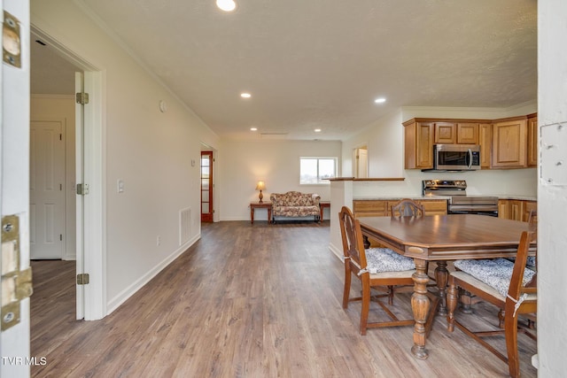 dining room with hardwood / wood-style floors and crown molding