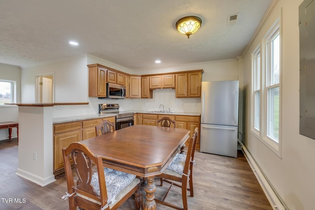 kitchen with hardwood / wood-style flooring, sink, stainless steel appliances, and a textured ceiling